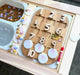White acrylic coins sits on a wooden learning board
