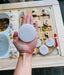 A large acrylic coin sits on a hand above a wooden board