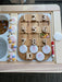 A set of acrylic coins sits on a wooden learning board for sensory bins