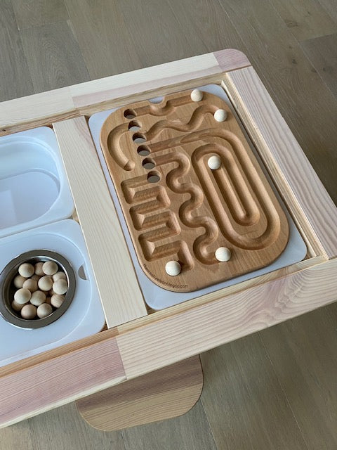 A wooden Learning Board™ sits on a sensory table
