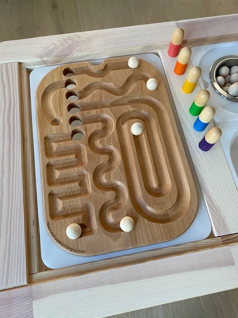 A wooden maze board with wooden balls