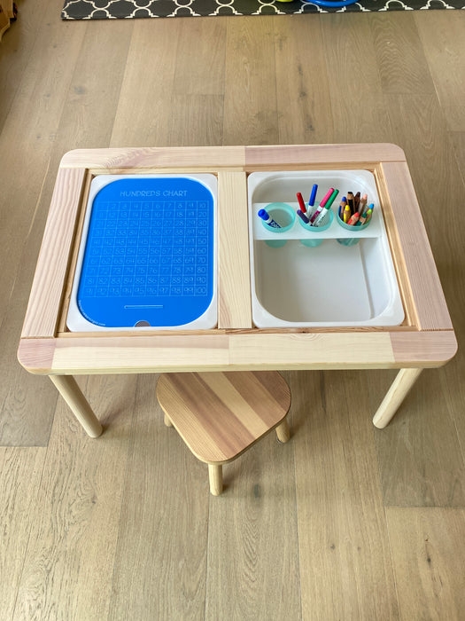 An acrylic hundreds board inside a sensory table