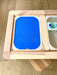 An acrylic hundreds board sits within a sensory flisat table