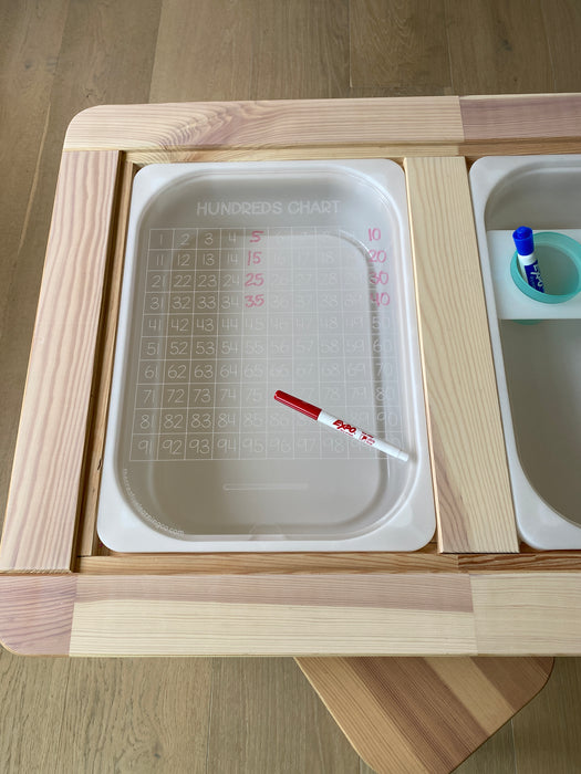 A clear acrylic hundreds chart with white board marker